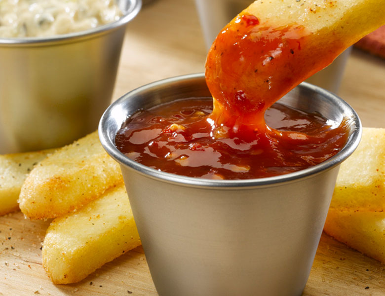 Steak Fry dipping into spicy sauce